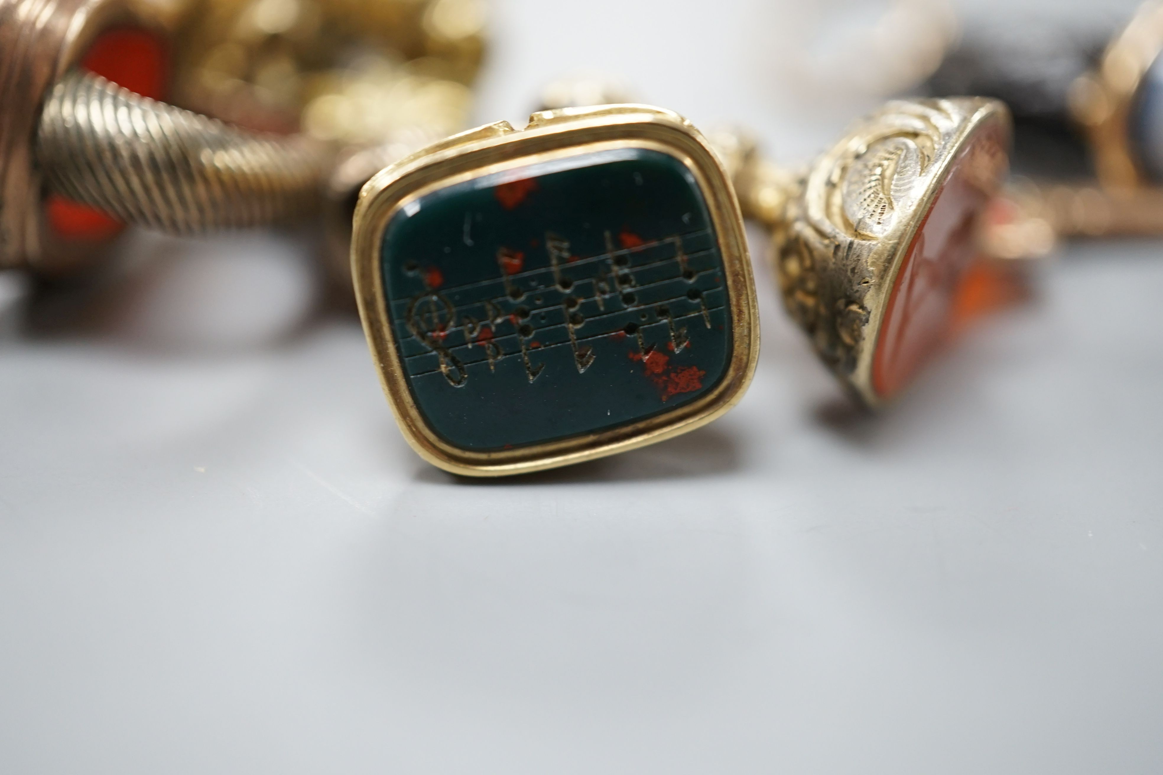 Eight assorted 19th century and later fob seals including a rose diamond set black glass dog with Roman head intaglio, 3cm, a gold overlaid and watch key